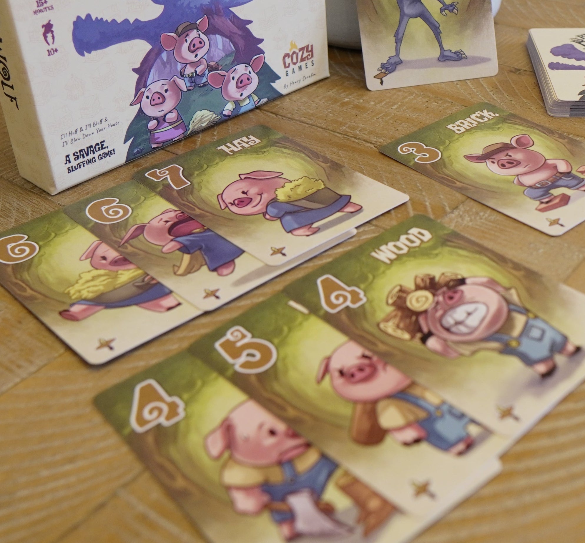Board game components including cards and a box on a wooden table
